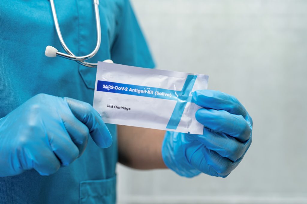 Asian doctor in PPE suit show positive test result with Saliva Antigen Test Kit