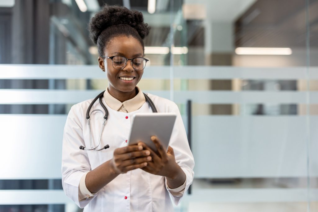 Smiling doctor using a tablet in a modern medical office
